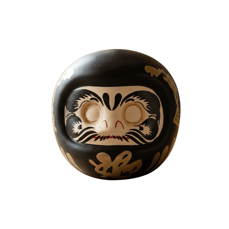 Black Daruma japanese doll with gold calligraphy and blank eyes for wish making ritual