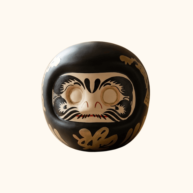 Black Daruma japanese doll with gold calligraphy and blank eyes for wish making ritual