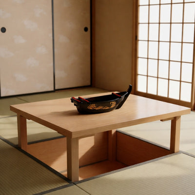 Black sushi boat lacquered with golden wave pattern on low wooden table in traditional tatami room setting