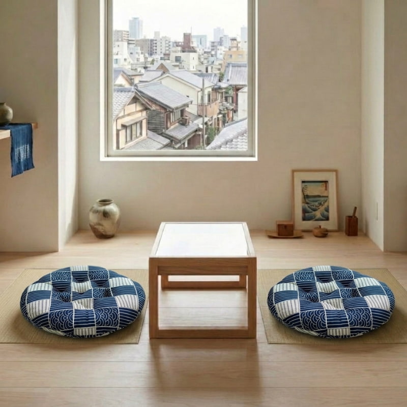 Two matching cushions in a blue Japanese wave pattern sit on the floor on either side of a low table with a city view