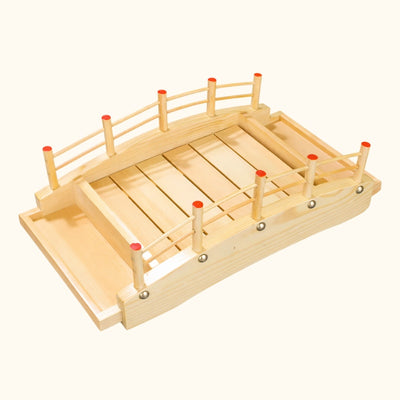 Boat sushi wooden bridge style platter with arched railings and red posts on clean white background