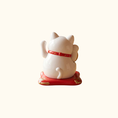 White Cat Japanese Maneki Neko lucky cat figurine, rear view with raised paws, red collar and decorative base