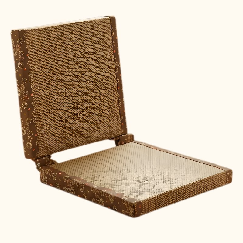 Chair floor tatami with brown woven surface and golden floral embroidery border on cream seat isolated on neutral background