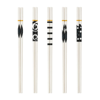 Set of 5 pairs of white ceramic chopsticks with five different black geometric patterns and gold bands, displayed on white background