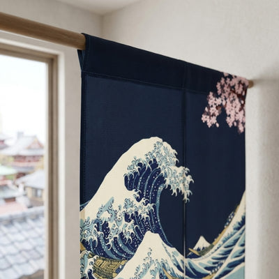 Close-up of curtain noren japanese door with deep navy Hokusai Great Wave and pink cherry blossom on wooden rod with traditional Kyoto rooftop view through window