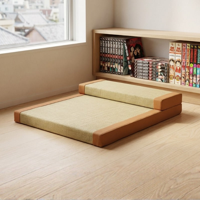 Cushion floor japanese with orange borders backrest and beige tatami surface near window with manga bookshelf collection