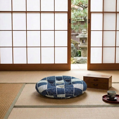 Near a shoji screen door, a Japanese cushion in blue rests on the tatami floor with a wave patchwork design