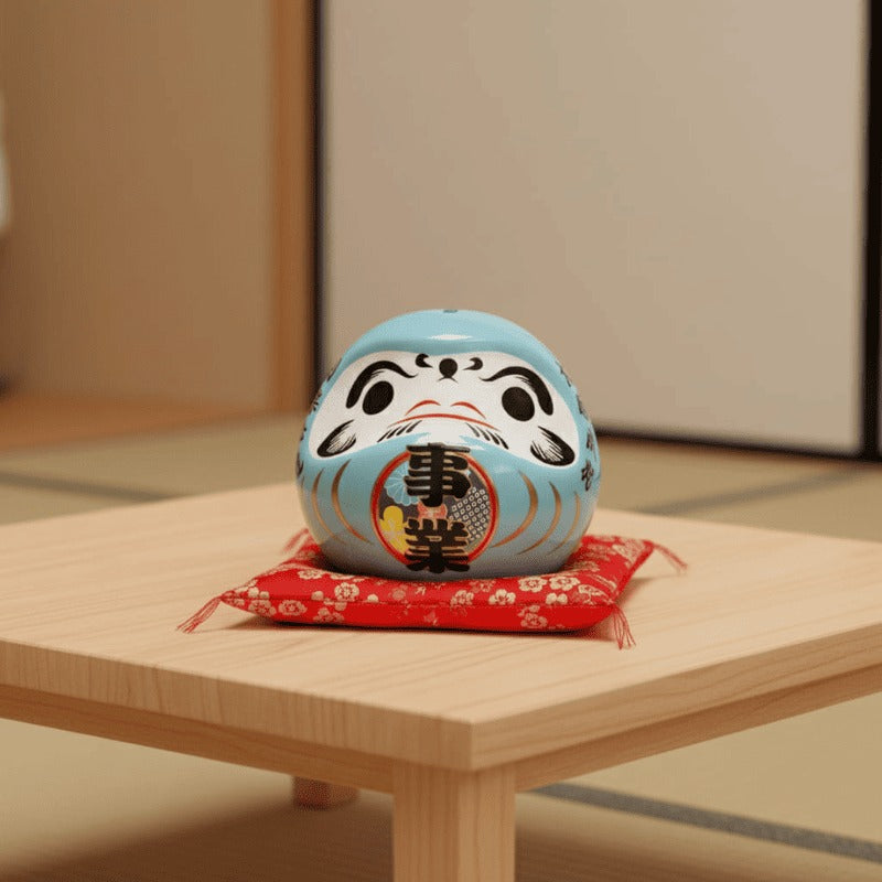 Serene daruma doll blue japanese ceramic with traditional kanji characters resting on red floral cushion beside wooden table in peaceful tatami floor room