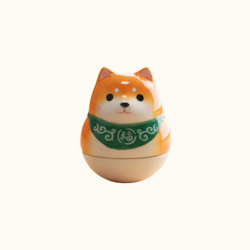 Orange daruma doll japanese shiba with green fortune collar and alert expression on clean white background