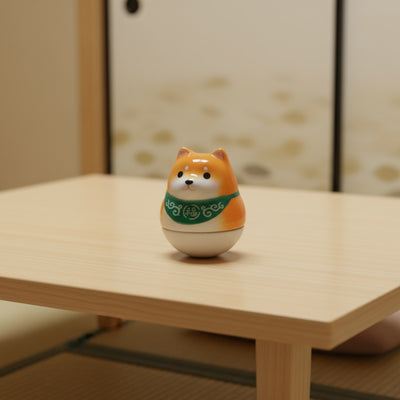 Cheerful daruma doll shiba japanese in orange with prosperity scarf on white surface in soft lighting