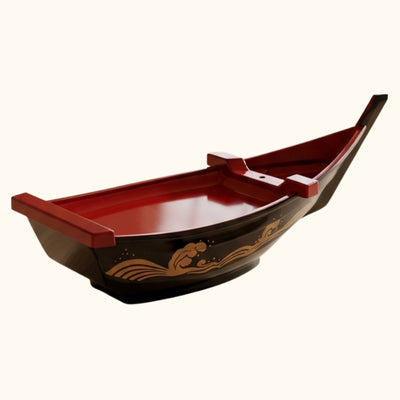 Floating boat sushi lacquered platter with red dividers and golden ocean pattern on neutral white background