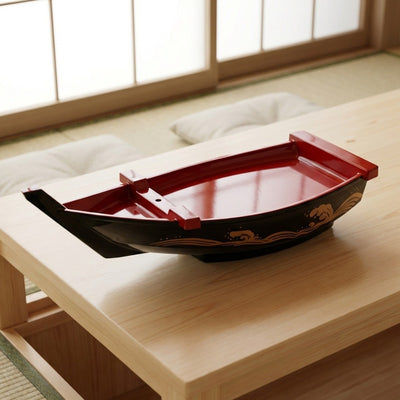 Floating sushi boat black and red curved presentation dish with gold decoration on minimalist low table