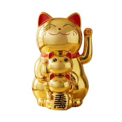 Glossy gold maneki neko cat statue with raised paw red collar and green bib holding fortune coin on clean white background