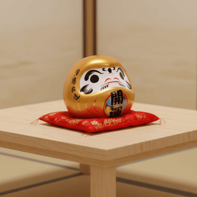 Prosperity focused gold daruma japanese in metallic finish with wealth kanji resting on red floral cushion atop small wooden table in neutral space