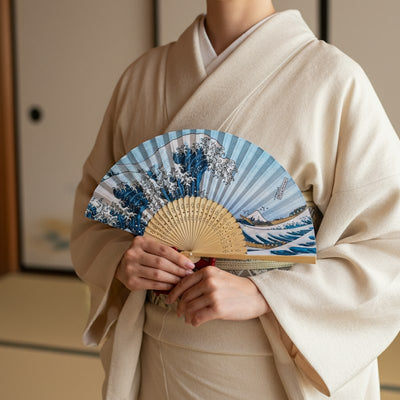 Authentic hand fan kanagawa with great wave design held by person wearing cream kimono in traditional Japanese interior with warm natural lighting