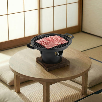Japanese barbecue style plate grilling marbled wagyu beef on round wooden table in authentic tatami floor setting with shoji doors