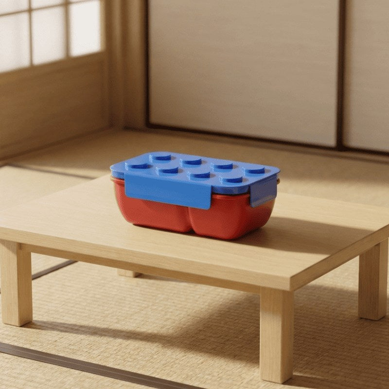 Vibrant japanese bento snack box featuring building block design placed on low wooden table beside shoji screen catching soft daylight