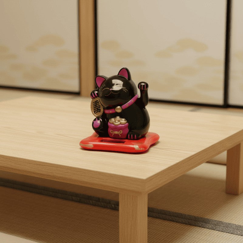 Elegant japanese black maneki neko cat with raised welcoming paws placed on red platform atop low wooden table in traditional tatami floor room