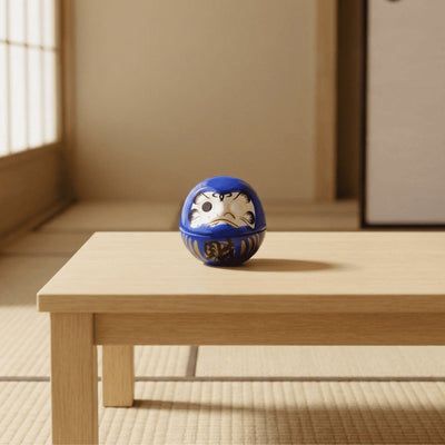 Japanese blue daruma with expressive facial features sitting on low wooden table beside tatami mat in serene traditional room