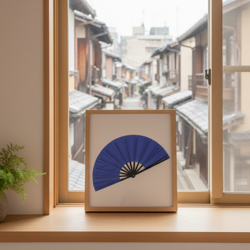 Elegant japanese blue fan displayed in wooden frame on window sill with snowy Kyoto street view creating peaceful winter atmosphere