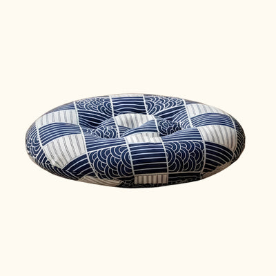 Set against a beige plain background, this blue Japanese floor cushion showcases an indigo wave pattern
