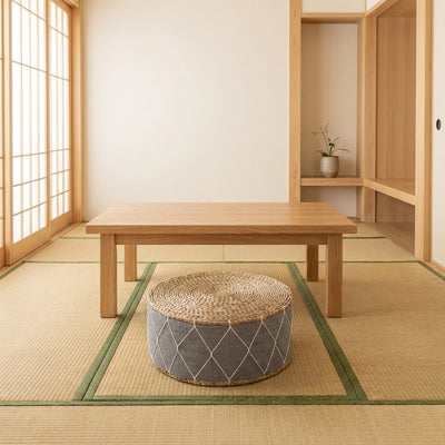 Japanese cushion seat with natural woven top and grey geometric fabric on tatami floor near chabudai table and tokonoma alcove