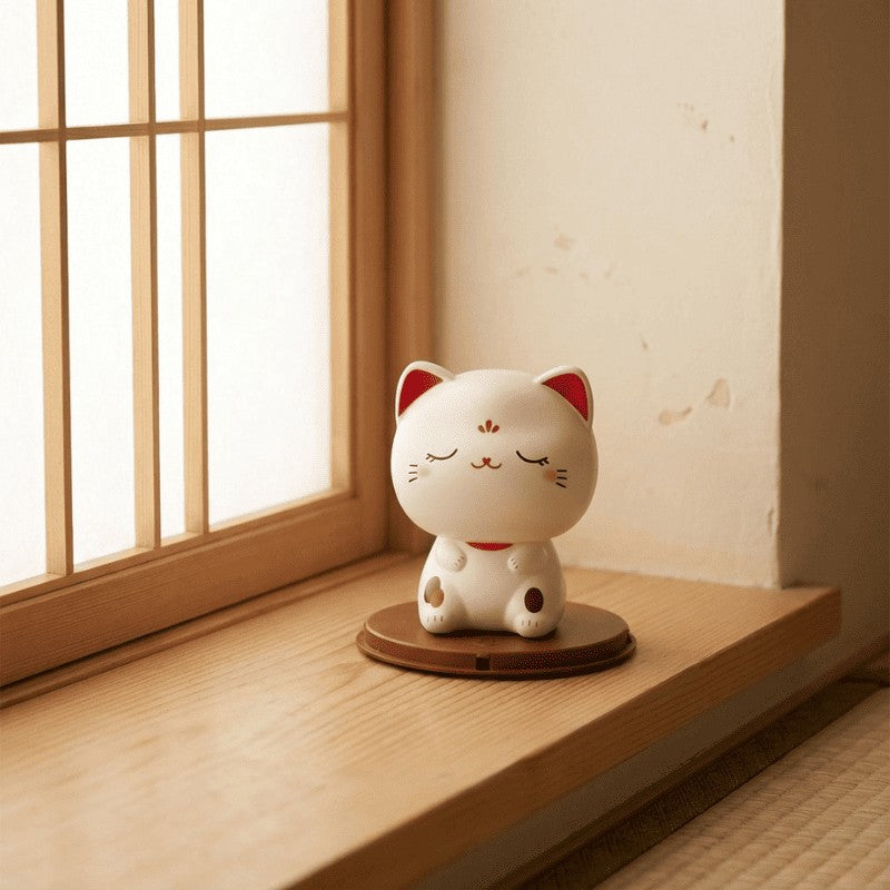 Tranquil maneki neko cute with peaceful closed eyes resting on wooden windowsill beside traditional Japanese lattice window in soft daylight