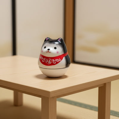 Adorable japanese daruma shiba with gray markings and red collar on low wooden table in serene setting