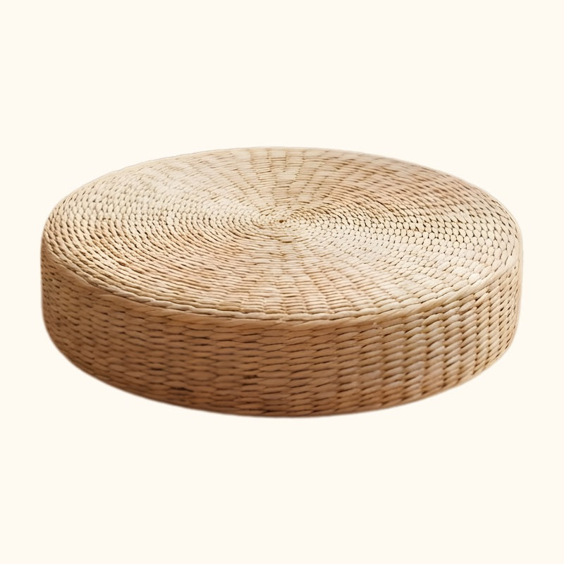 Japanese floor cushion round in natural woven seagrass with spiral pattern on white background