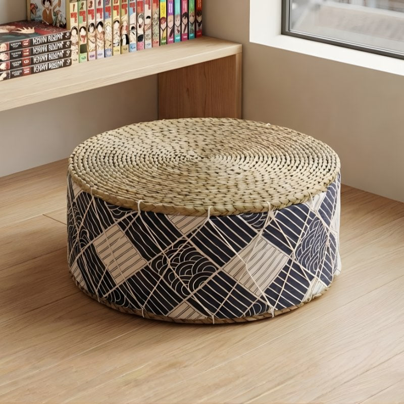 Japanese floor cushion with woven rattan top and geometric navy blue pattern near manga bookshelf in modern apartment