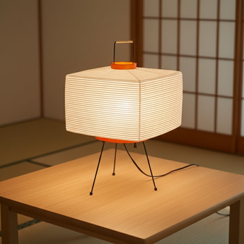 Modern japanese floor lamp style featuring square shade with horizontal lines and orange accents on wooden table in traditional interior