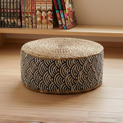 Japanese floor seat cushion in round shape with woven rattan top and seigaiha wave pattern fabric near manga bookshelf