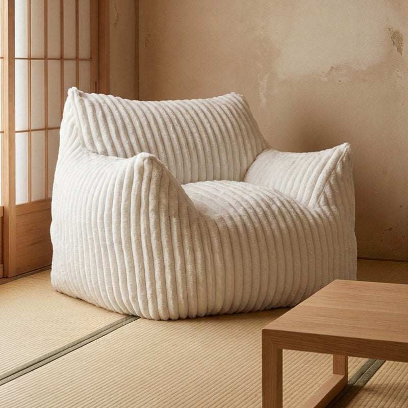 Japanese floor sofa armchair with white ribbed upholstery on tatami mat near shoji screen and wooden coffee table