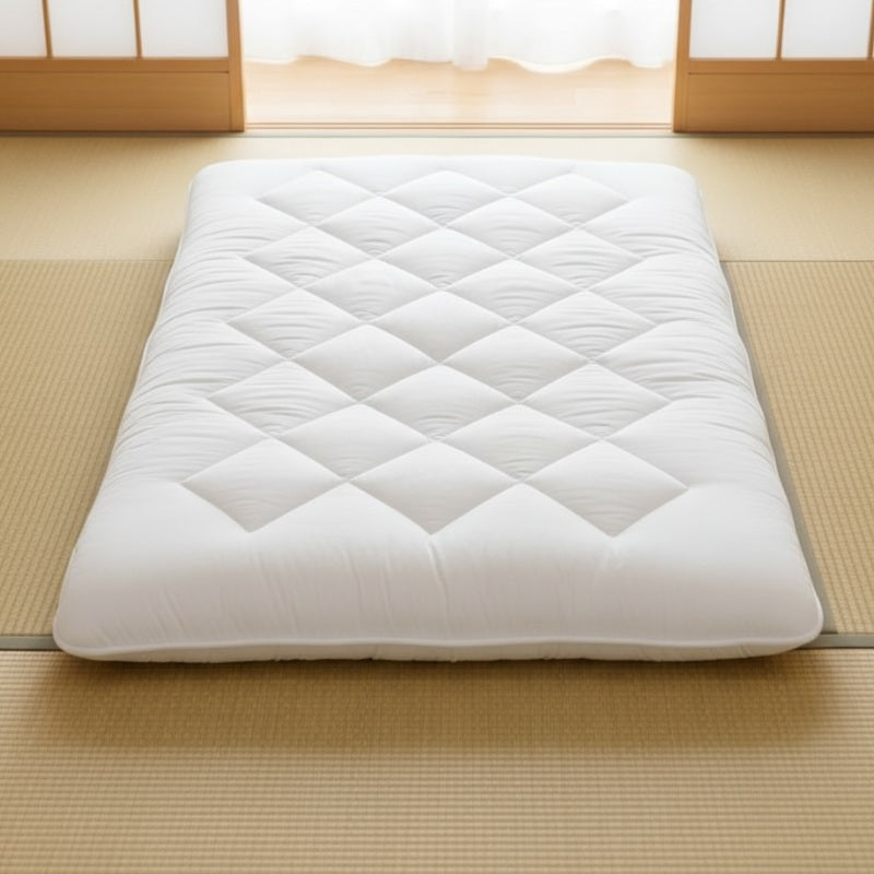 Japanese futon style with white quilted surface and wave pattern on tatami floor near shoji screen in traditional setting