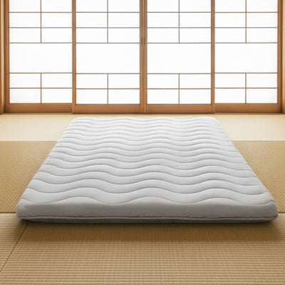 Classic japanese futon with wave quilting pattern positioned on traditional tatami mat floor near bright shoji screens in serene interior