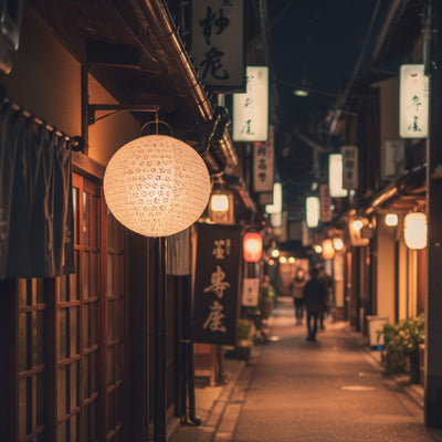 Glowing japanese lantern hanging outside traditional shopfront at night with multiple lanterns creating atmospheric lighting along narrow alley