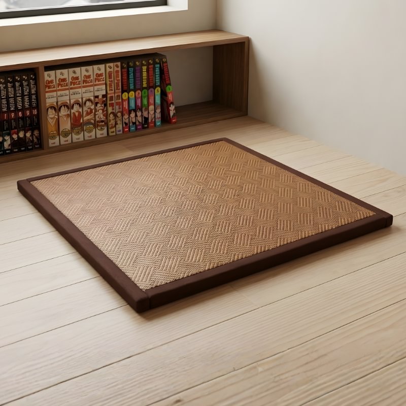 Japanese mat in natural rattan with herringbone weave pattern and brown border near manga collection shelf on wooden floor