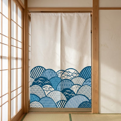 Traditional japanese noren doorway curtain with indigo seigaiha wave pattern on cream fabric hanging in authentic tatami room framed by light wood shoji sliding panels