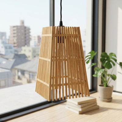 Japanese pendant light fixture tapered bamboo design near modern window with monstera plant and cityscape urban background view