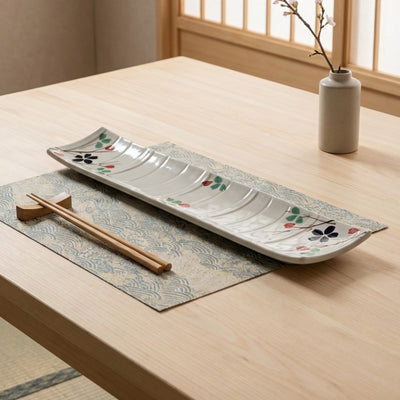 Elegant japanese plate sushi with handpainted floral motifs and wave texture on natural wood table setting
