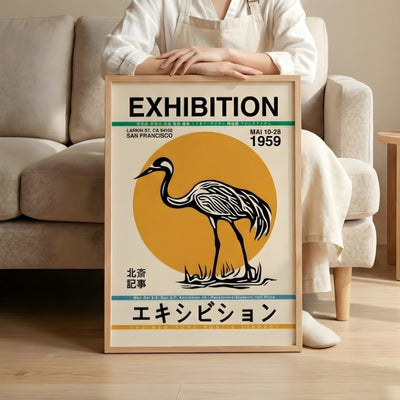 Classic japanese poster featuring crane bird and orange sunset from 1959 exhibition held by person in minimalist living room setting