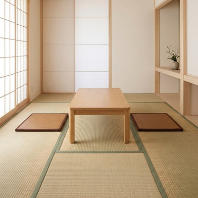 Japanese rattan mat pair with brown borders flanking wooden chabudai table on tatami floor with fusuma doors and tokonoma alcove
