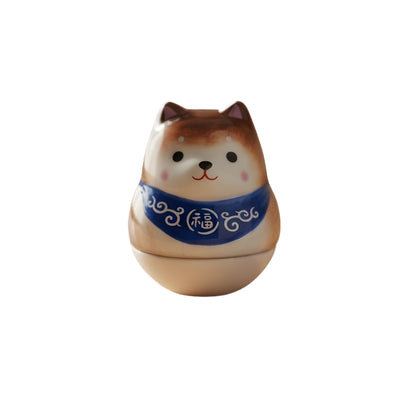 Natural japanese shiba daruma in beige with blue fortune collar and gentle smile on white background