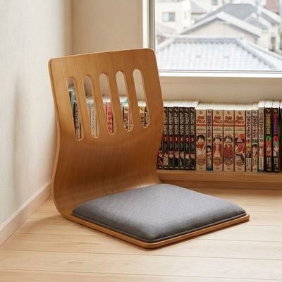 Japanese tatami chair with curved bentwood back on light flooring near bookshelf with manga volumes and window