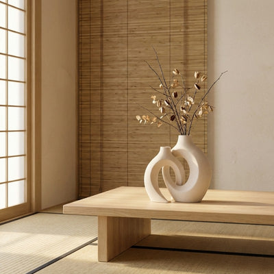 Sculptural japanese vintage white vase with circular cutout design and dried botanicals on tatami table