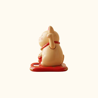 Cream Maneki Neko Cat Japanese figurine, side view with raised paw, red collar and traditional lucky cat design