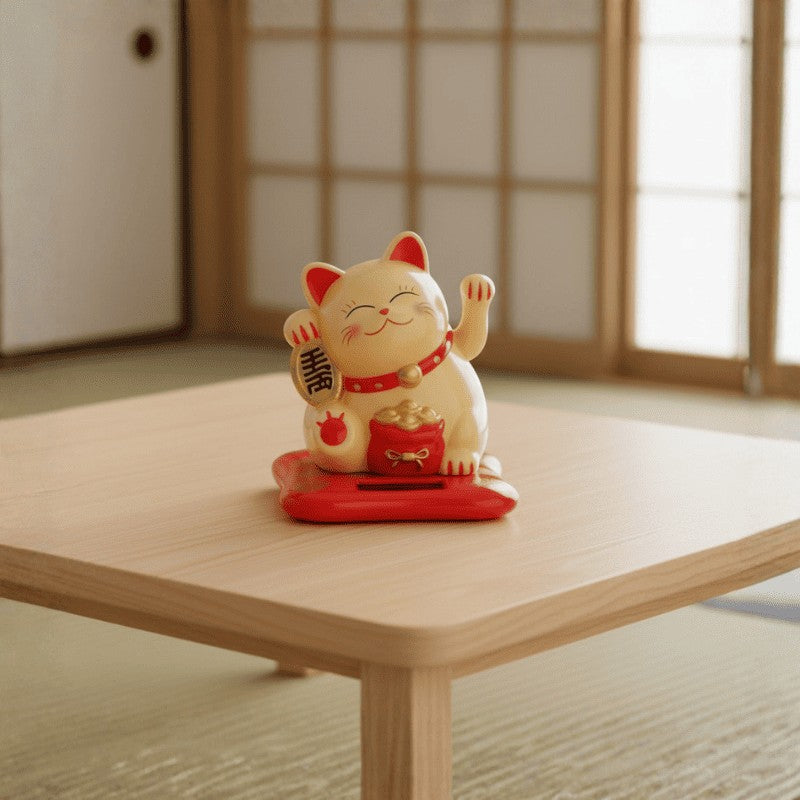 Fortune bringing maneki neko japanese cat in cream finish with raised paws placed on red base atop low wooden table in peaceful tatami setting