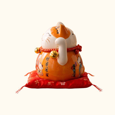 Orange Maneki Neko Lucky Japanese figurine, side view with golden bells and decorative Japanese patterns