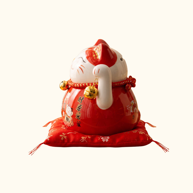 Red Maneki Neko Statue Japanese figurine, side view with golden bells and traditional decorative patterns