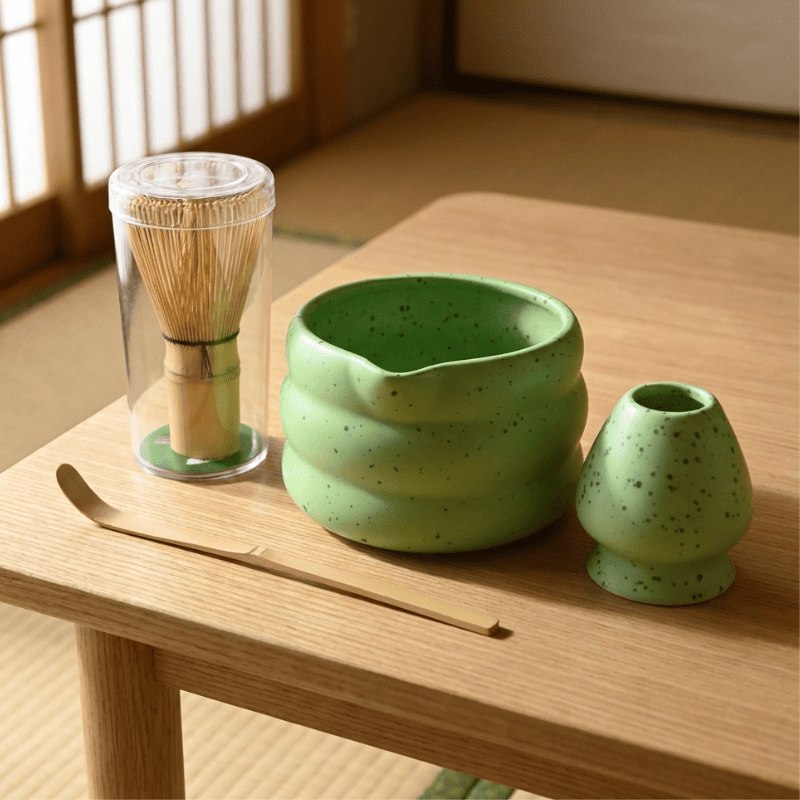 Jade green matcha bowl set japanese style with bamboo tools arranged on wooden table near traditional sliding door in soft daylight